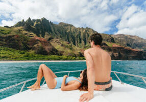 Couple views Napali Coast from bow of tour boat - Credit: Hawaii Tourism Authority (HTA) / Ben Ono
