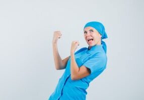 female-doctor-showing-winner-gesture-blue-uniform-looking-happy-front-view 1200x800